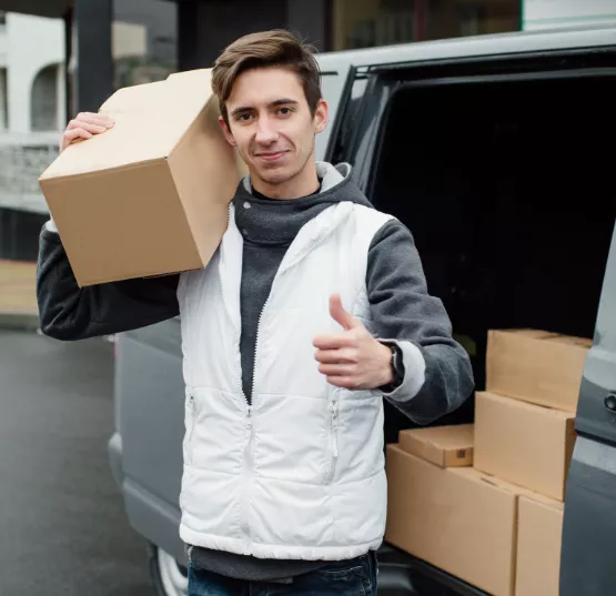 Mover holding a cardboard box and showing thumbs up